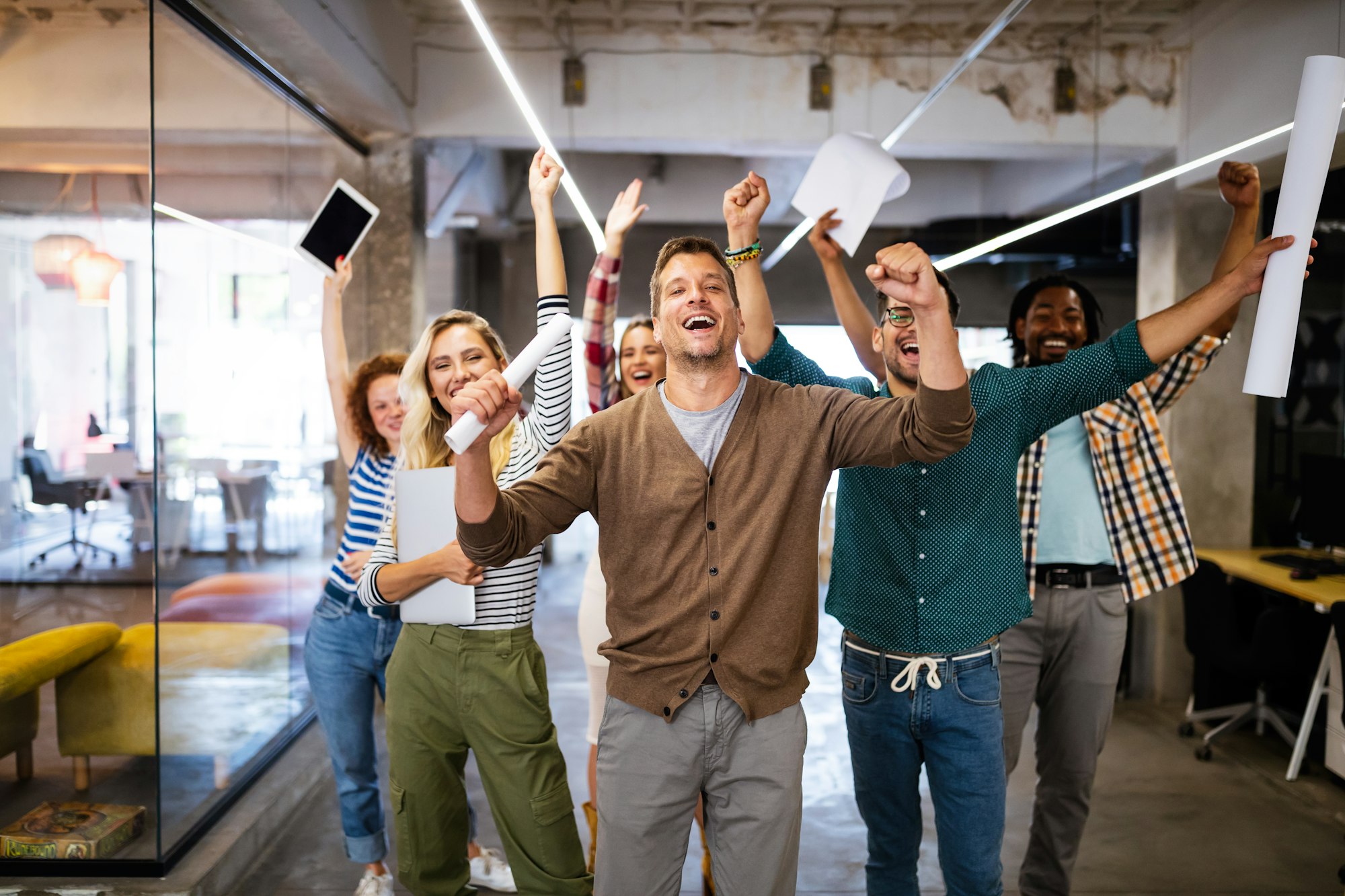 Erfolgreiches Unternehmen mit glücklichen Mitarbeitern im modernen Büro: Betriebliche Krankenversicherung als MAKEMORE-Benefit